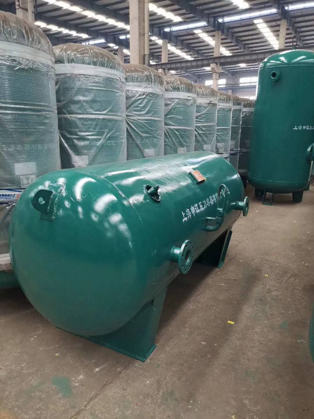 large green tank sitting in a warehouse