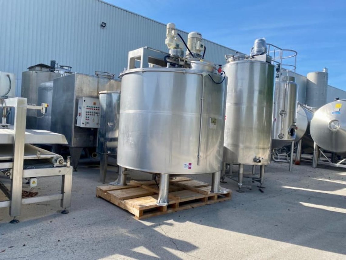 a group of stainless steel tanks sitting next o each other