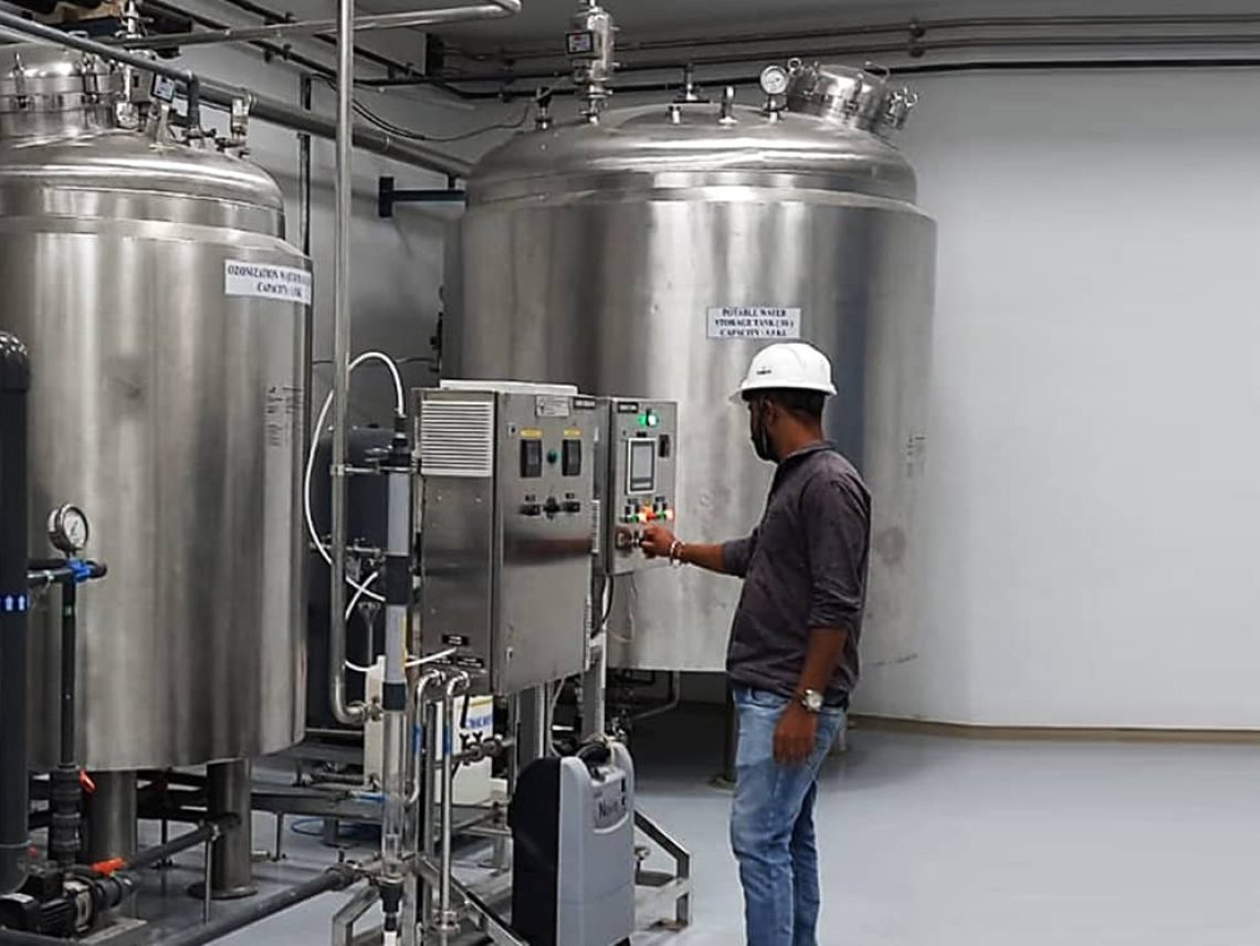 a man in a hard hat standing in front of a machine