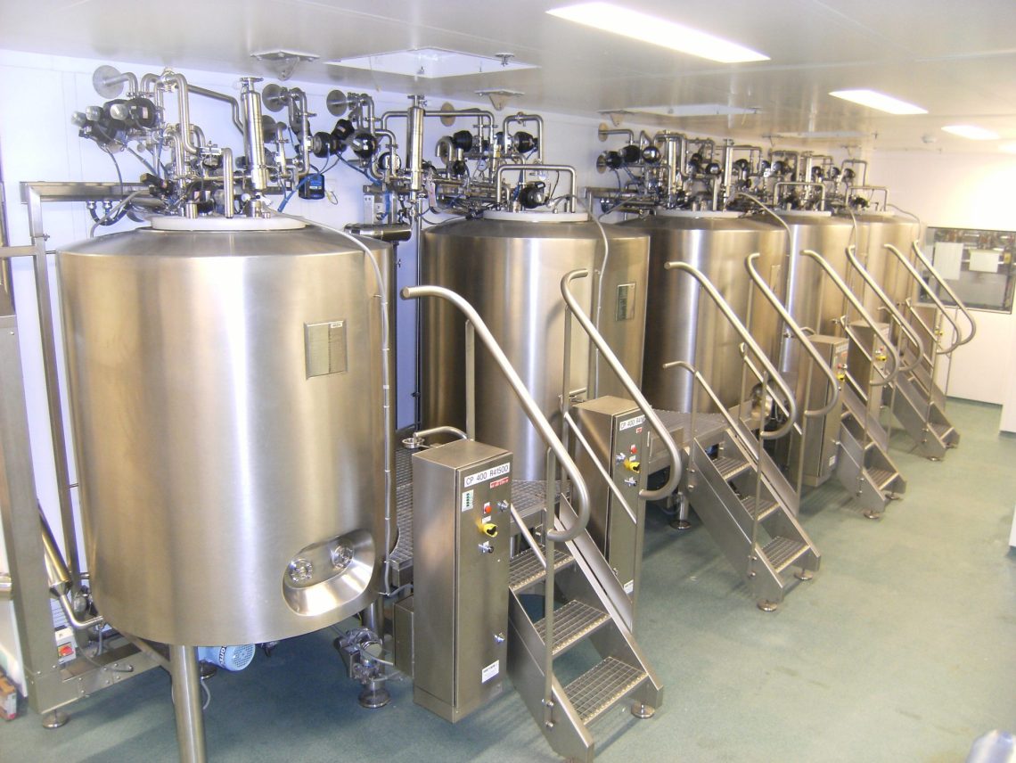 a row of stainless steel tanks in a factory