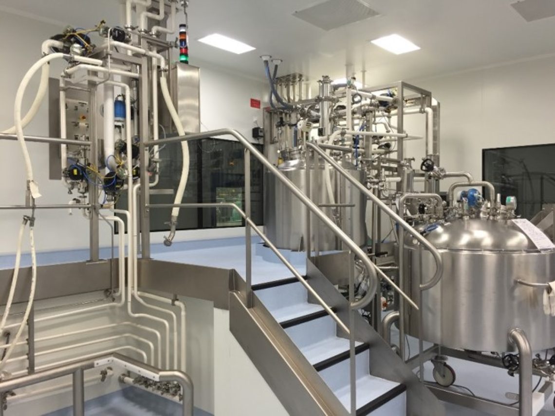 a set of stairs leading up to a room filled with stainless steel tanks