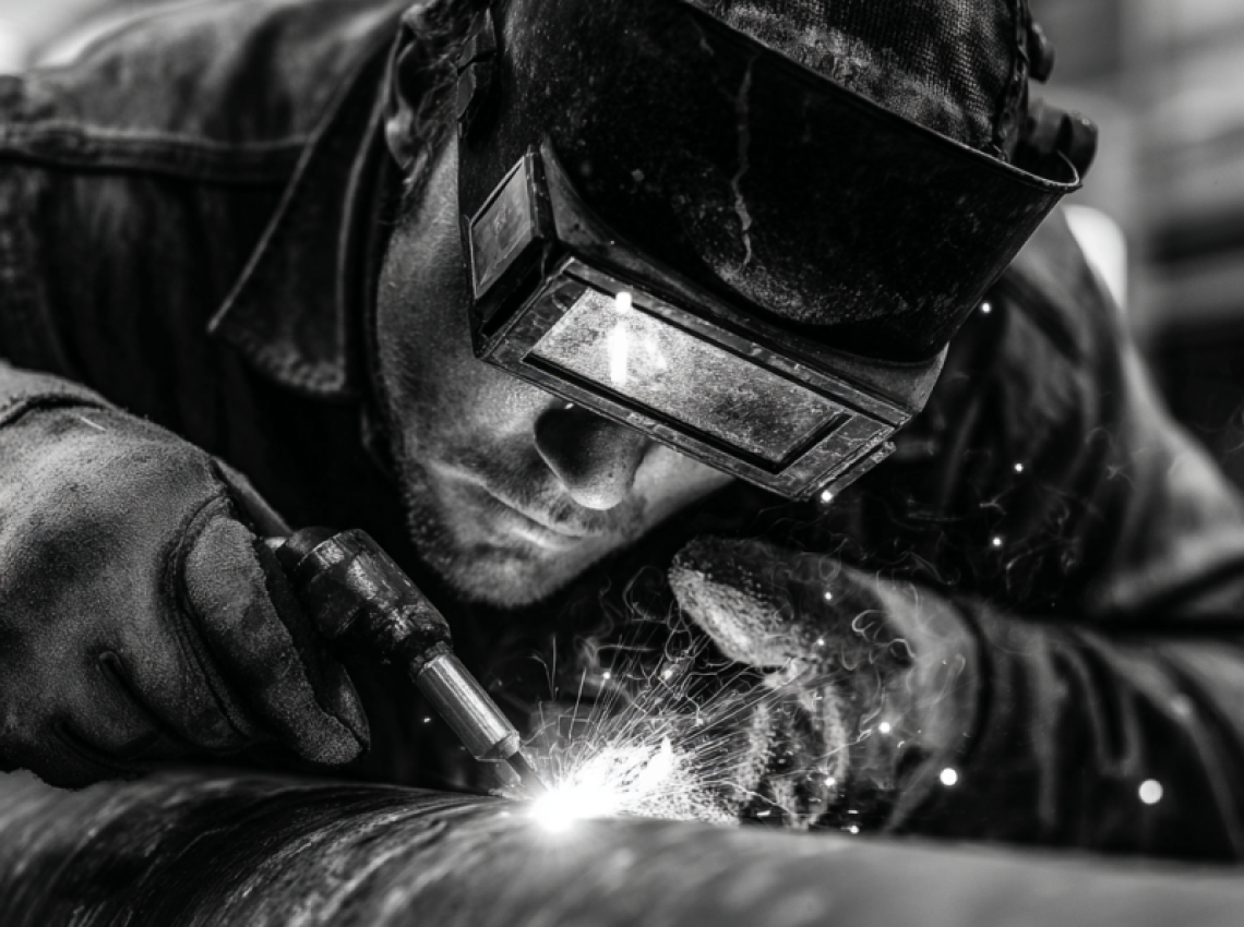 Welder demonstrating what is 5g welding position on a fixed horizontal pipe
